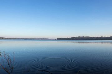 Circles on the blue lake with blue sky.