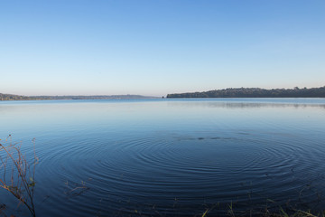 Circles on the blue lake with blue sky.