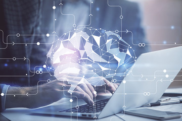 Man typing on keyboard background with brain hologram. Concept of big Data.
