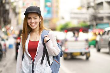 Young asian woman traveler bag backpacker on street at Yaowarat road outdoor market in Bangkok,...