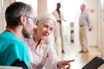 Doctor Welcoming To Senior Female Patient Being Admitted To Hospital