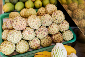 Box of fresh ripe cherimoya fruits at supermarket or food market