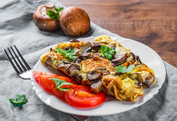 omelette with mushrooms in white plate on wooden table background