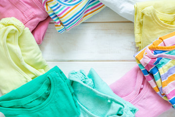 Marie Kondo tyding up method concept - folded kids clothes in pastel colors, copy space