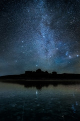 Starry night sky over the silhouette of the mountains. The milky way. © Vasily