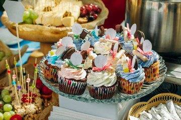 Tasty cupcakes on a crystal dish with empty white signs.