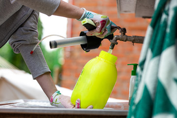 Water being added into a sprayer with pesticide