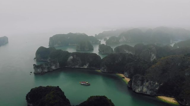 Beautiful view of Halong Bay from the height. Top view of the rocks sticking out of their water. northern vietnam. Seascape. Mountains in fog. 4K move drone