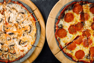 Two Pizza one with chicken breasts and mushrooms, the second pepperoni with salami sausage.