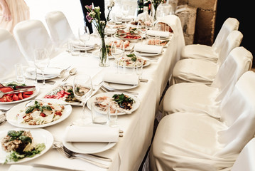 stylish luxury decorated table with flowers and delicious food, celebration wedding, catering in the restaurant