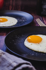 Fried eggs on black plate
