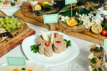 Homemade pate laid out on a white plate, with a slice of loaf.