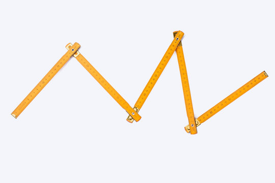 Folding ruler on white background. Image of yellow wooden yardstick. Carpenters tool with scale of numbers.