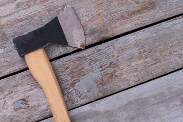 Rusty axe on old wooden boards. Used axe on rustic wooden planks.