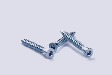 Hardware screws nails for construction on a white background. Three screws isolated on white background.