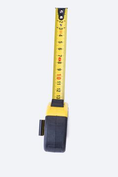 Measuring tool on white background. Yellow measuring tape, vertical image.
