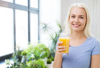 healthy eating, dieting and people concept - smiling woman drinking orange juice from glass at home