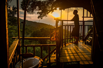 Woman at sunset in a treehouse near Houayxai, Laos