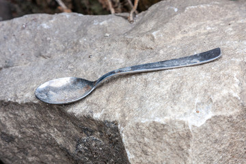 old dirty spoon abandoned on a stone