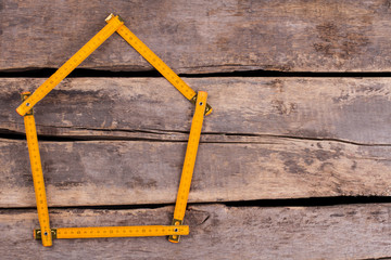 House made from yellow folding ruler. Yellow folding ruler in a shape of house. Space for text....