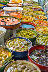 Marinated olives with herbs in a market.