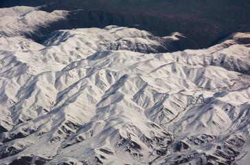 Fototapeta premium Snowy mountains view from plane during winter, Iranian Highlands