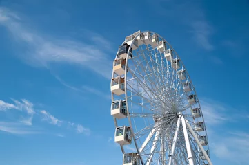 Deurstickers Ferris wheel on blue sky with white clouds background. © Alex Puhovoy