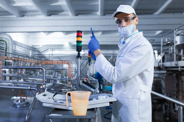 man in a white robe and a cap make an inspection of the production line