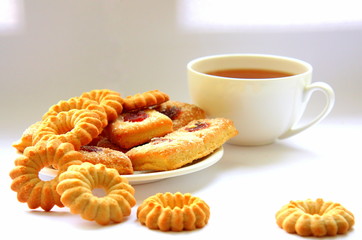  A variety of shaped cookies. White cup of tea. Morning is sweet. Tea ceremony.