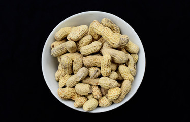 Peanuts on a plate with a blank black background