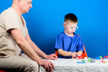 Illness treatment. Dad and son medical dynasty. Medical examination. Boy cute child and his father doctor. Hospital worker. Health care. Medicine concept. Kid little doctor sit table medical tools