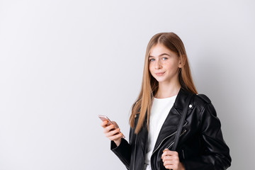 Obraz premium Stylish teenage girl with mobile phone on light background
