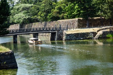 国宝松江城の内堀　宇賀橋付近から北惣門橋を見ると堀川をめぐる遊覧船が北惣門橋を通過している