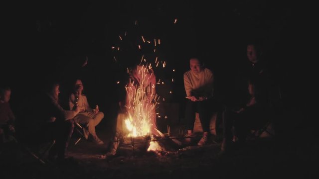 Family on a picnic near a campfire in the dark