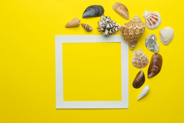 Summer frame. Paper frame for your text and seashells on a bright yellow background. top view