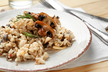 Plate with tasty risotto on wooden table