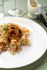 Plate with tasty risotto on wooden table