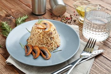 Plate with tasty risotto on wooden table