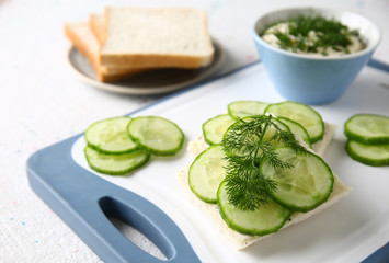 Tasty cucumber sandwiches on board, closeup