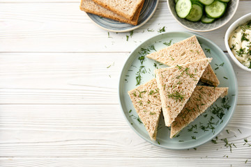 Plate with tasty cucumber sandwiches on white table