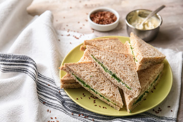 Plate with tasty cucumber sandwiches on table