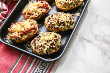 Plate with tasty stuffed potato on light table