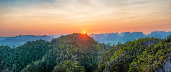 Panorama of tropicall landscape with dramatic sunset and steep mountain ridge on horizon. Krabi, Thailand