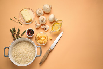 Raw ingredients for risotto on color background