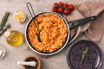 Frying pan with tasty risotto on table