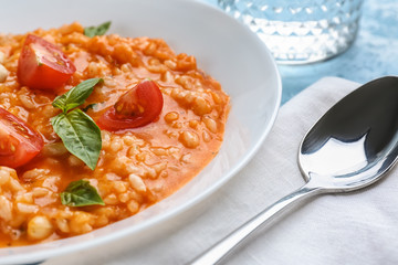 Plate with tasty risotto on table, closeup