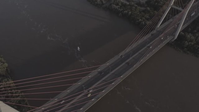 Top view of the road Siekierkowski bridge passing through the river Vistula in the city of Warsaw. Filmed from 4K drone in RAW. Video for post-processing.