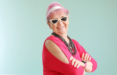 Portrait of stylish senior woman on grey background