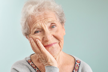 Portrait of senior woman on grey background