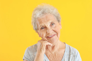 Portrait of senior woman on color background